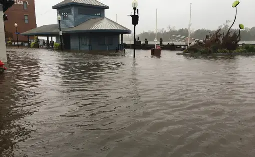 Wilmington North Carolina - USA / September 14, 2018. Downtown Wilmington begins to flood from storm surges. Visitor center on the foot of Market and Water St covered half way with flood waters. Image by MicheleMidnight / Shutterstock.com. United States, 2018.