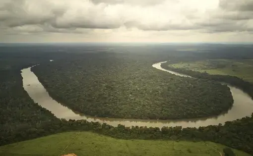 Visão aérea de um trecho no rio dos Peixes onde se pode ver o contraste entre a área desmatada na margem não indígena do rio e a área preservada dentro da Terra Indígena na outra margem. Image by: Pablo Albarenga. Brazil, 2019.