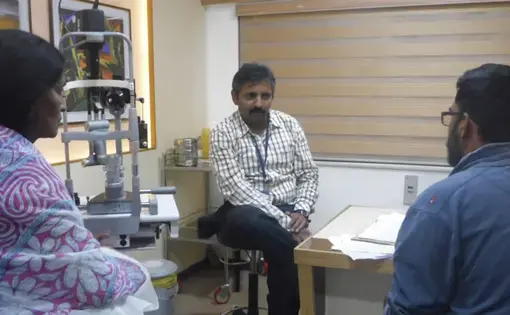 a leading eye specialist at Sankar Nethralaya, interacts with a patient and her son.