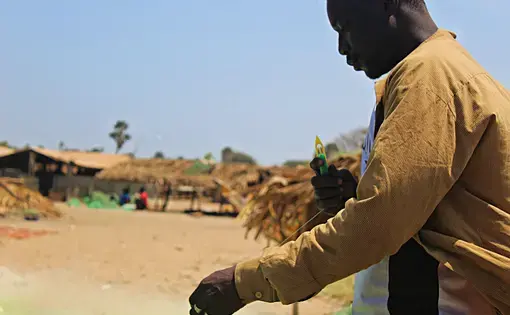 Edrissa Sackh and his captain Abdulai Camara mend their fishing net on Gunjur beach. These small-scale fishermen catch the majority of fish critical to food security. Image by Nosmot Gbadamosi. Gambia, 2018.