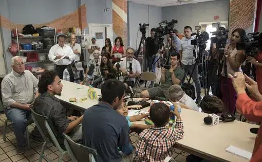Left to right: Director of the Annunciation House Ruben Garcia, Roger (only first names given), Pablo Ortiz and his 3-year-old son Andres (off frame) and 4-year-old Roger Jr. speak to the media during a press conference at the Annunciation House in El Paso on July 11, 2018. The fathers and sons were released the previous night by ICE. Image by Ivan Pierre Aguirre for the Texas Tribune. United States, 2018.