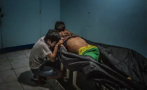 Ginnalyn Soriano and her youngest brother, Jonas, at the morgue with their eldest brother, Julius. Image by James Whitlow Delano. Philippines, 2017.