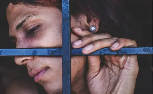 A bruised transgender woman is forced to wait for trial confined with male prisoners, many of whom abuse her. Image by Ana María Arévalo. Venezuela, 2017.