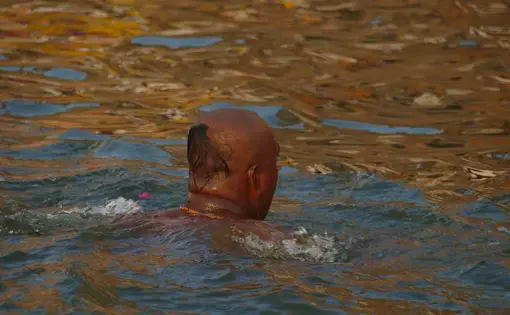 A pilgrim takes a holy dip in river Ganges