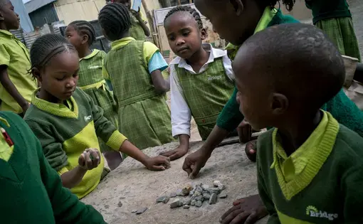 Students play with rocks outside Bridge Diamond in the Mukuru slum in Nairobi. Image by Diana Zeyneb Alhindawi for The New York Times. Kenya, 2017.