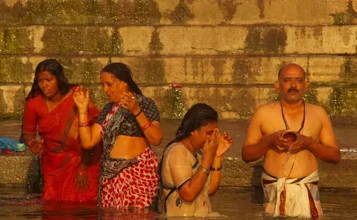 Pilgrims take a “holy dip” in the sacred river. Image by George Black. India, 2015.