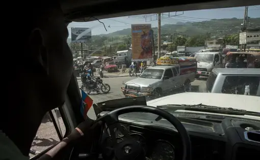 Elide Jean Petrus, 46, drives a truck through traffic in downtown Port-au-Prince, Haiti. Image by Marie Arago. Haiti, 2017.