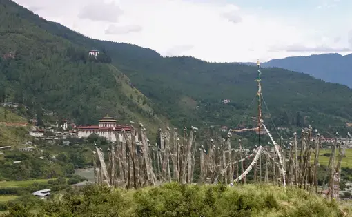 A view of prayer flags and the Paro dzong, or fortress, in Paro, Bhutan. Image by Emma Johnson. Bhutan, 2019.