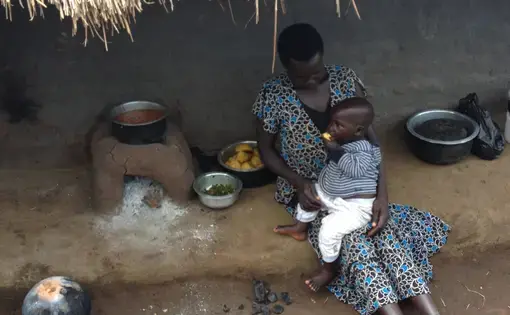 Lunchtime in northern Uganda. A mother and her child enjoy sweet potatoes rich in Vitamin A and beans with higher iron content. Image by Roger Thurow. Uganda, 2014. Media file: img_0071.jpg