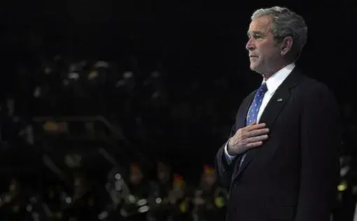 President George W. Bush places his hand on his heart while the national anthem plays during the Armed Forces Full Honor Farewell to President George W. Bush on Fort Myer, Va., Jan. 6, 2009. CC BY 2.0. United States, 2009.