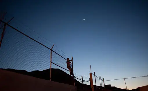 A member of the Novenos climbs a fence. The city closed of the football courts where they hang out in an effort to keep the neighborhood safe. They gather there anyway and worry that if attacked they would be unable to flee. Image by Dominic Bracco II. Mexico, 2016.
