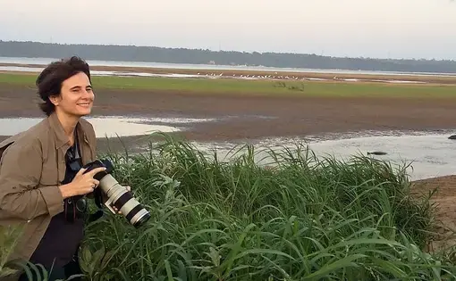 Eliane Brum stands in the Tabuleiro do Embaubal of the Amazon Rainforest, where turtles are hatched. Image by João Luiz Guimarães. Brazil, 2019.
