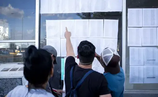 Cuban migrants look at a list of asylum seekers near the Gateway International Bridge in Matamoros, Tamaulipas. Image by Miguel Gutierrez Jr. Mexico, 2019.