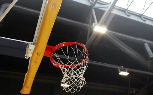 Basketball hoop in the sports center against the dark ceiling. Image by Andrew Makedonski / Shutterstock.