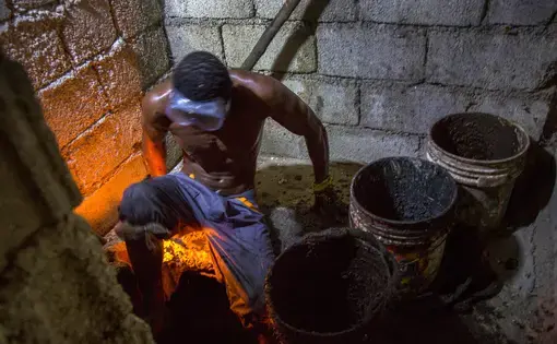 Gabriel Toto, 35, has been working as a bayakou, or latrine cleaner, for a decade. On nights without a journalist watching, he generally works naked. Image by Marie Arago/NPR. Haiti, 2017.