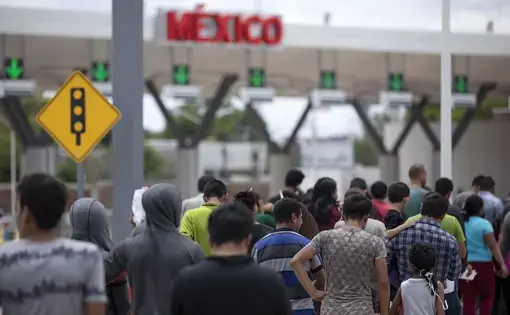 Migrants walk across International Bridge Two into Nuevo Laredo from Laredo. They requested asylum in the United States but were returned to Mexico to await their court proceedings. Image by Miguel Gutierrez Jr. United States, 2019.