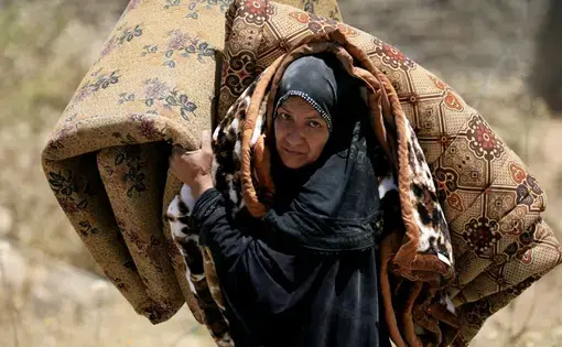 An Iraqi woman fleeing her home in Mosul in 2017. Image by Alaa Al-Marjani with Reuters. Iraq, 2017.