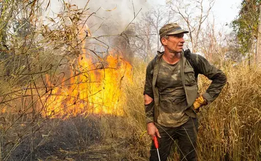 Ben Davis, an independent American conservationist, takes a break from battling a fire in the Phnom Tnout Wildlife Sanctuary, where he lives with his family in northern Cambodia. Fires in the area are lit by farmers, loggers, and local people looking to either capture wildlife or clear land for agriculture. In 2018, fires burnt in record numbers throughout the forests of north and central Cambodia. At their peak during the dry season between January and March, it is estimated up to 1,800 fires were burning…