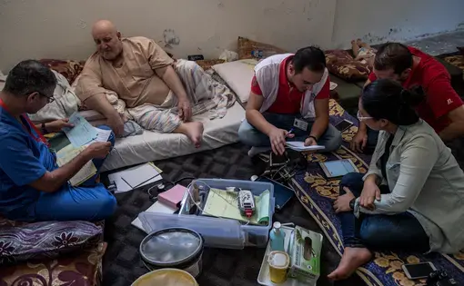 A doctor from Médecins Sans Frontières speaks with Ibrahim Hassan, a Syrian refugee living in Northern Jordan. Staff from the Dharma Platform collect information and prepare to deploy new data-collection technology along the Syrian border. Image by Neil Brandvold. Jordan, 2017.