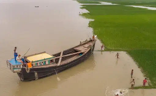 The photographer George Steinmetz spent a year traveling the world to document climate change. In this image, from Bangladesh in Sept. 2017, he is in the boat flying the drone that took this photo. Image by George Steinmetz. Bangladesh, 2017.