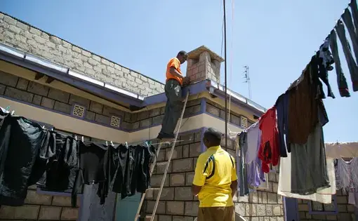 A StarTimes satellite dish is installed on Francis Gitonga's roof in Kajiado, Kenya. Gitonga said the new digital TV package, with Chinese and Kenyan programs, gave him better reception than he’d once thought possible in the town. Image by Immanuel Muasya. Kenya, 2017. 