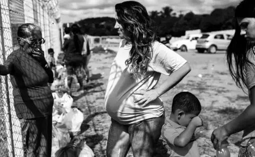 A pregnant woman, who did not want to be identified, waits for the gates to open to visit her boyfriend outside Alcaçuz Federal Penitentiary. Image by Lianne Milton. Brazil, 2018.
