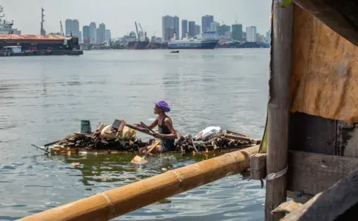 People in Manila create numerous opportunities to make a living for themselves, such as looking for scraps of wood in the bay to make lump charcoal. Image by Micah Castelo. Philippines, 2019.