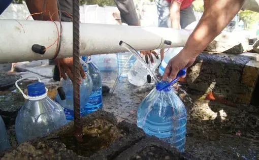Residents collect water from a makeshift and unregulated water source at Springs Way. Image by Jacqueline Flynn. South Africa, 2018. Residents collect water from a makeshift and unregulated water source at Springs Way. Image by Jacqueline Flynn. South Africa, 2018.