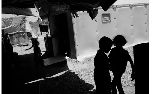 Black and white image of children in silhoutte from an IDP camp in Iraq.