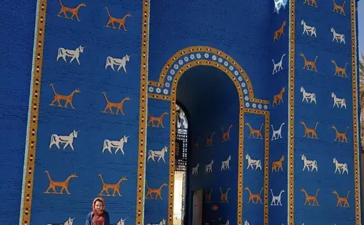 Zahra Ahmad, 24, stands in front of the blue wall leading into the ancient kingdom of Babylon, Iraq in Feb. 2019. Image courtesy of Ahmad family. Iraq, 2019.