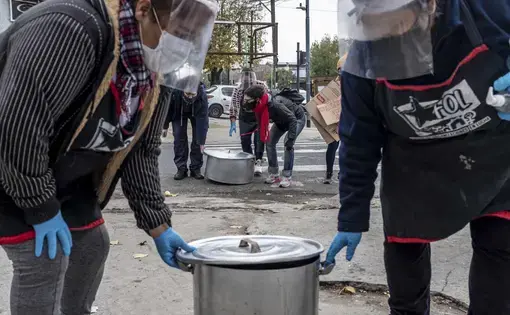 Women from Frente de Organizaciones en Lucha’s “Berta Cáceres” soup kitchen carry their pots for a public soup kitchen in Villa 1-11-14, Buenos Aires, Argentina. Image by Anita Pouchard Serra. Argentina, 2020.