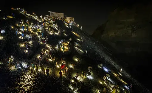 Freelance miners search for jade stones at night with torchlights on a waste site in Hpakant, Kachin State, Myanmar on May 21, 2019. Image by Hkun Lat. Myanmar, 2019.