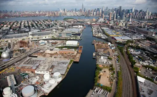 Newtown Creek, a 5.5 kilometer-long tributary of New York’s East River, is one of the most heavily industrialized and polluted sites in the United States. Water overflowed the armored banks of the waterway during Hurricane Sandy, spreading untreated sewage and toxic chemicals into city streets and basements. The Newtown Creek Wastewater Treatment Plant (the silver egg-shaped tanks on the far left), the largest of New York’s 14 sewage processing facilities, was responsible for the sewage—it released 550…
