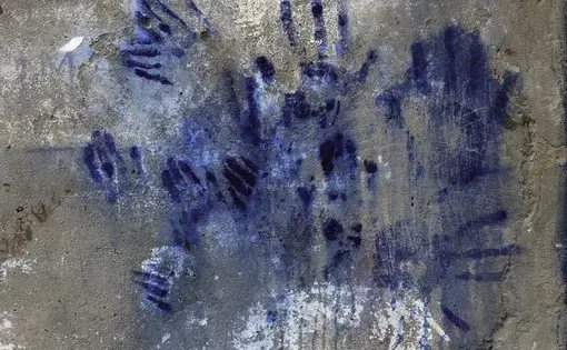 Handprints in chromium sulfate accumulate on the outside of a tannery wall. Workers pat the walls during breaks to wipe chemicals from their hands.