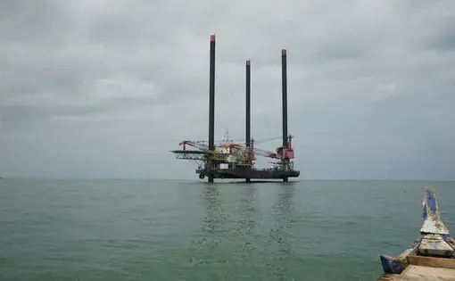 Oil production vessels like this now dot the west coast of Ghana. Employees will usually work for a few weeks on the vessel and then for a few weeks on the mainland. This photo was captured from a traditional fishing canoe, the main method of navigating the ocean for most of Ghana's fishermen. Image by John Soper. Ghana, 2015. Media file: c.well_from_view_of_fishing_boat_copy.jpg