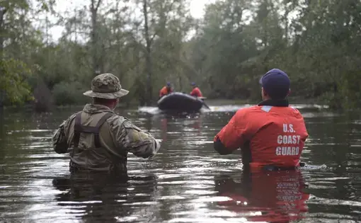 Members of Coast Guard Maritime Safety and Security Team Miami and Coast Guard Tactical Law Enforcement Team South wait to be picked up by their rescue team after completing Hurricane Florence search and rescue operations in Brunswick County, September 16, 2018. Image by Petty Officer 3rd Class Trevor Lilburn. United States, 2018.