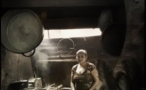 Some three billion people around the world cook their food and heat their homes with open or barely contained fires. Here, a woman stands near her household cooking fire in San Antonio Aguas Calientes, Guatemala. Photo by Lynn Johnson. Guatemala, 2017.