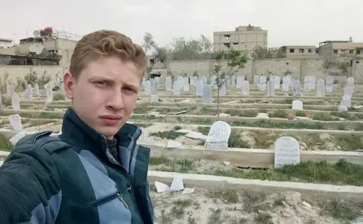Muhammad Najem visits the tomb of his father one final time before being evacuated from Eastern Ghouta. Image courtesty of Muhammad Najem/Facebook. Syria, 2018.