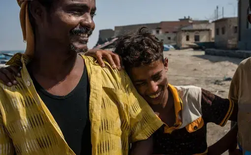 Shafai Saleh Hadi (left) laughs with local boys on the shore of Bir Fuqum. As a first-generation fisherman, he sees the job as a better route for his sons than attending school, since employment is incredibly scarce in Yemen. Image by Alex Potter. Yemen, 2018.