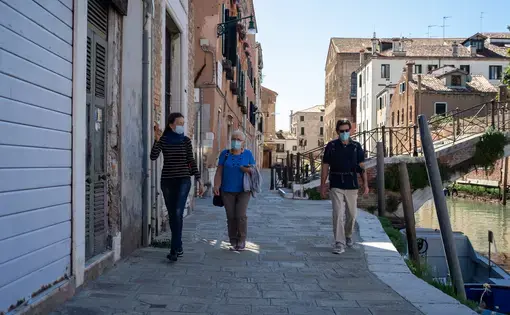 A guide with tourists just after the reopening of Venice after the lockdown. Image by Simone Padovani. Italy, 2020.