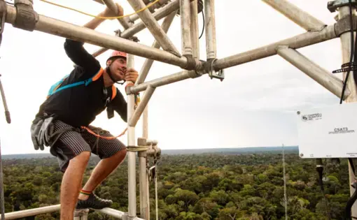 Researcher Delano Campos scales an 80-meter tower at the Amazon Tall Tower Observatory to collect air samples and maintain instruments. Image by Victor Moriyama. Brazil, 2019.
