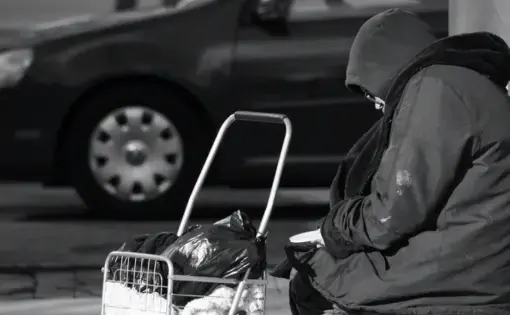 Atlanta, Georgia/United States-January 24 2018: An unidentified homeless person sits on a bench in midtown Atlanta on Peachtree Street. Image by Image Alleviation/Shutterstock. United States, 2018.