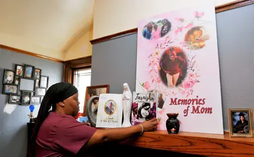 Wyconda Clayton looks at photos of her late mother on the mantle in her Milwaukee duplex. Image by Pat A. Robinson. United States, 2020.