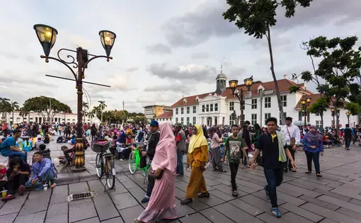 A large crowd of local people spend their Sunday afternoon around the fatahillah Square in Jakarta colonial old town named Kota. Image courtesy of AsiaTravel/Shutterstock. Indonesia, 2017.