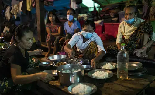 People prepare dinner at the Shitthaung camp for displaced people in Mrauk U, Myanmar, on Aug. 20. International humanitarian access to the township has been largely blocked since early 2019, and many camps are run by local civil society organizations and community volunteers. Image by Hkun Lat/Foreign Policy. Myanmar, 2020.