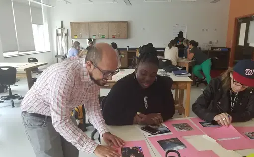 Teachers look at photos from the Everyday series as Fareed Mostoufi from the Pulitzer Center guides them through the Everyday DC unit. Image by Kayla Sharpe. United States, 2017.