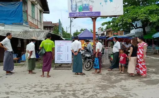 Residents of the town of Mrauk-U in Rakhine State, Myanmar gather around a COVID-19 information board created by a local civil society organization. Following a 14-month block on all internet services, the Myanmar government restored 2G services in August but continues to block 3G and 4G networks in eight conflict-affected townships, including Mrauk-U. Myanmar, 2020.