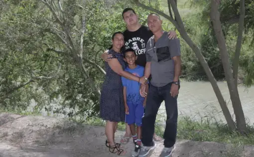 Clockwise from left to right: Mairen Barbara Almora, Abel Aguilar Almora (21 years old), Abel Aguilar Columbie, Sergio Almora (9 years old), pose for a photo by the Rio Grande on the Mexican side of the border. Image by Jose A. Iglesias. Mexico, 2019.