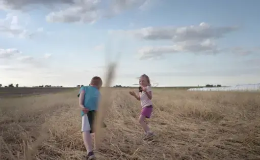 Keota, Iowa – Children play in Tim Sieren’s cover crops while the Practical Farmers of Iowa group meet about conservation implementation. Image by Spike Johnson. United States, 2019.