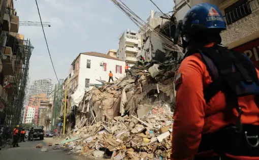 Rescue workers dig through the rubble of a badly damaged building in Lebanon's capital, Beirut, in search of possible survivors from a mega-blast at the adjacent port one month ago, after scanners detected a pulse, on September 3, 2020. A sniffer dog used by Chilean rescuers responded to a scent from the site of a collapsed building in the Gemmayzeh area, the city's governor told reporters at the scene. Image by Joseph Eid/AFP. Lebanon, 2020.